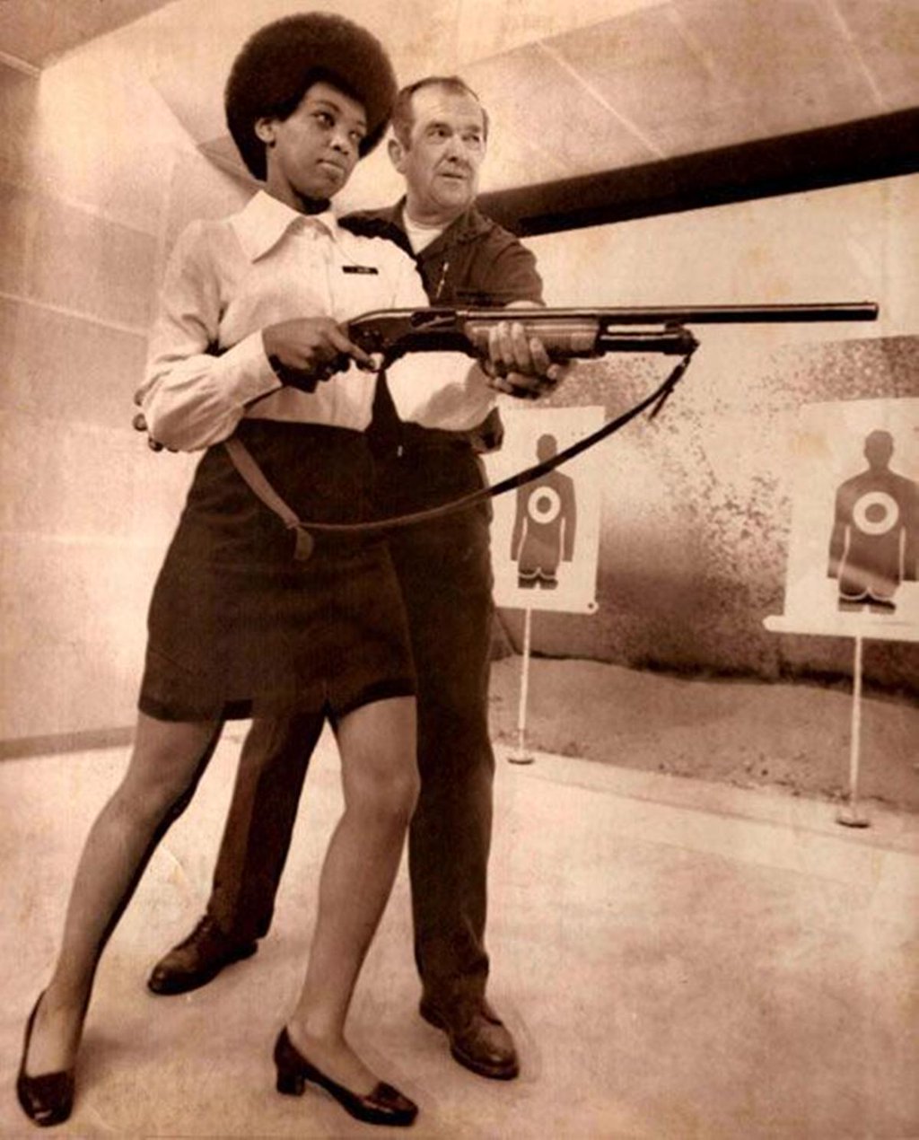 9. Saundra Brown, the first black woman on the Oakland police force, gets instructions on how to shoot a shotgun, 1970.
